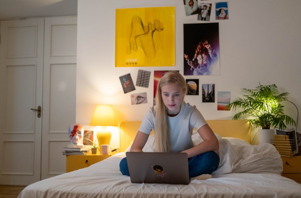 Child refusing to see parent in Australia. Teenage girl on her laptop in bed.