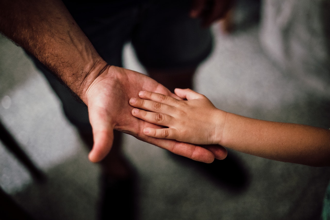 Child’s hand in father’s hand. Child custody Australia.