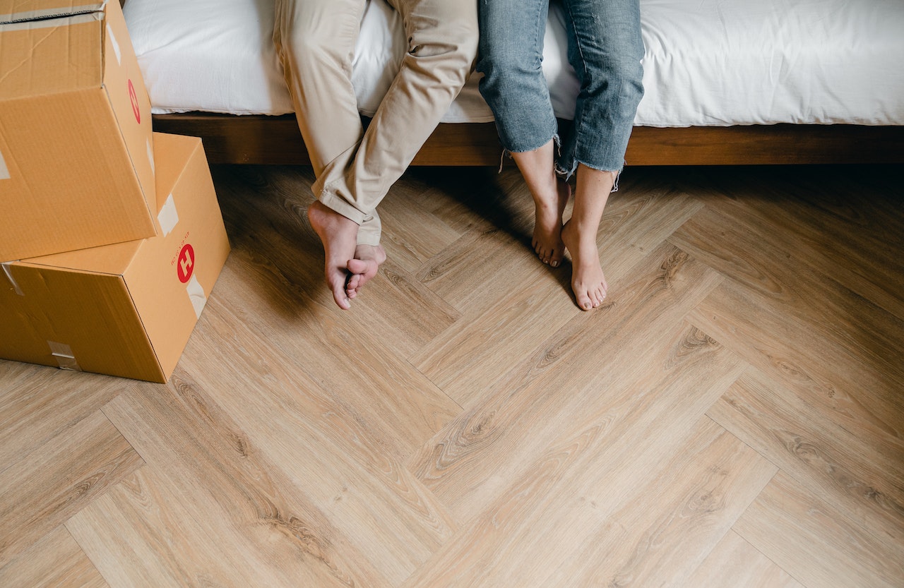 Couple sitting on bed near packed boxes. Benefits and limitations of prenups in Australia. 